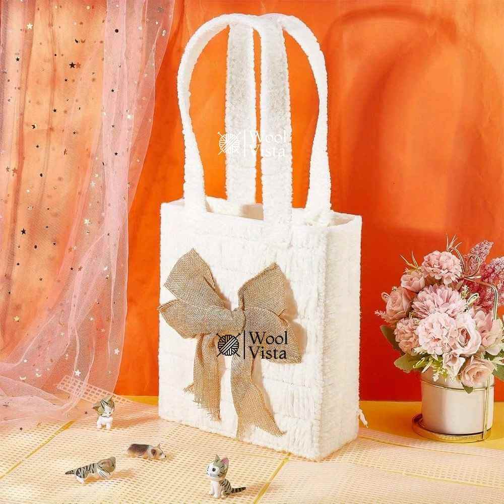 Finished white crochet tote bag with burlap bow made from a plastic mesh canvas kit